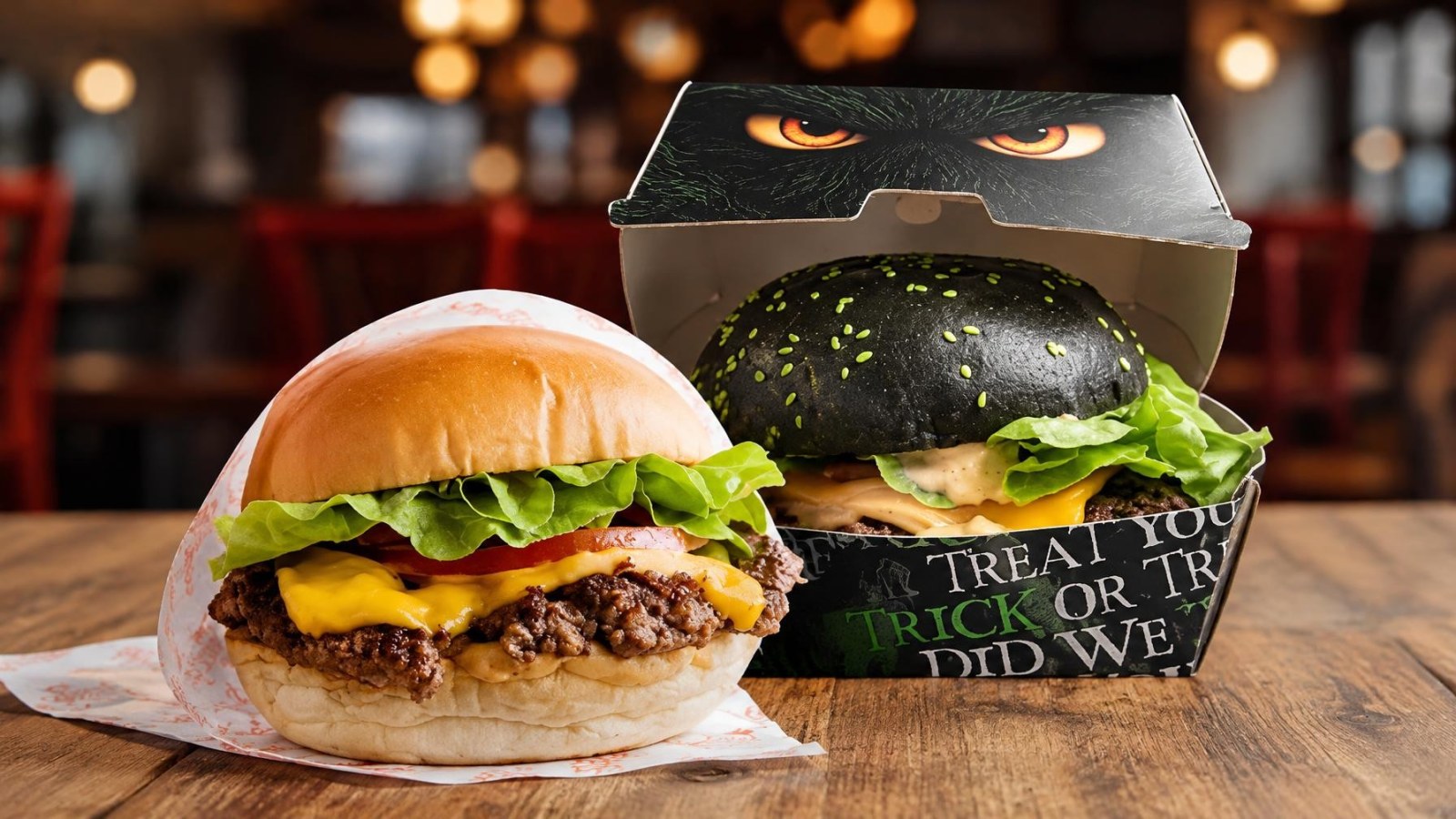 Betty’s Burgers Offers Buy One, Get One Free Burgers for Halloween on October 31 8 Two burgers on a wooden table, one with a classic bun and the other with a black bun in a Halloween-themed box
