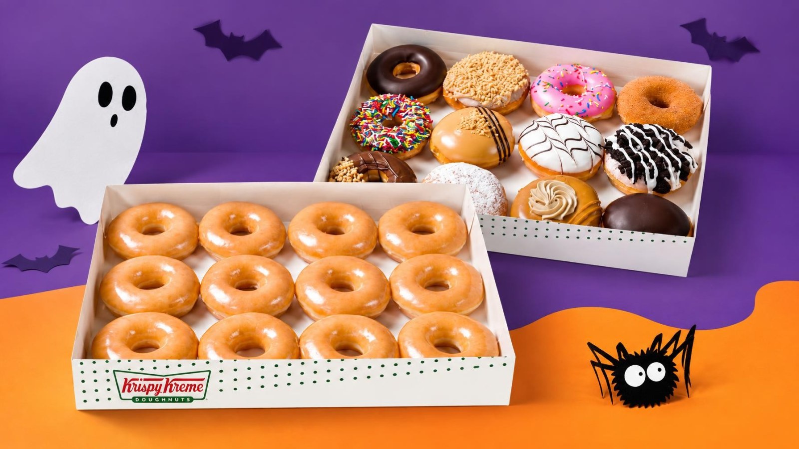 Krispy Kreme Gives Away Free Original Glazed Dozen with Any Dozen Purchase for Halloween 1 Two open boxes of doughnuts with Halloween-themed decorations in background, one box of plain glazed doughnuts and one box of assorted decorated doughnuts